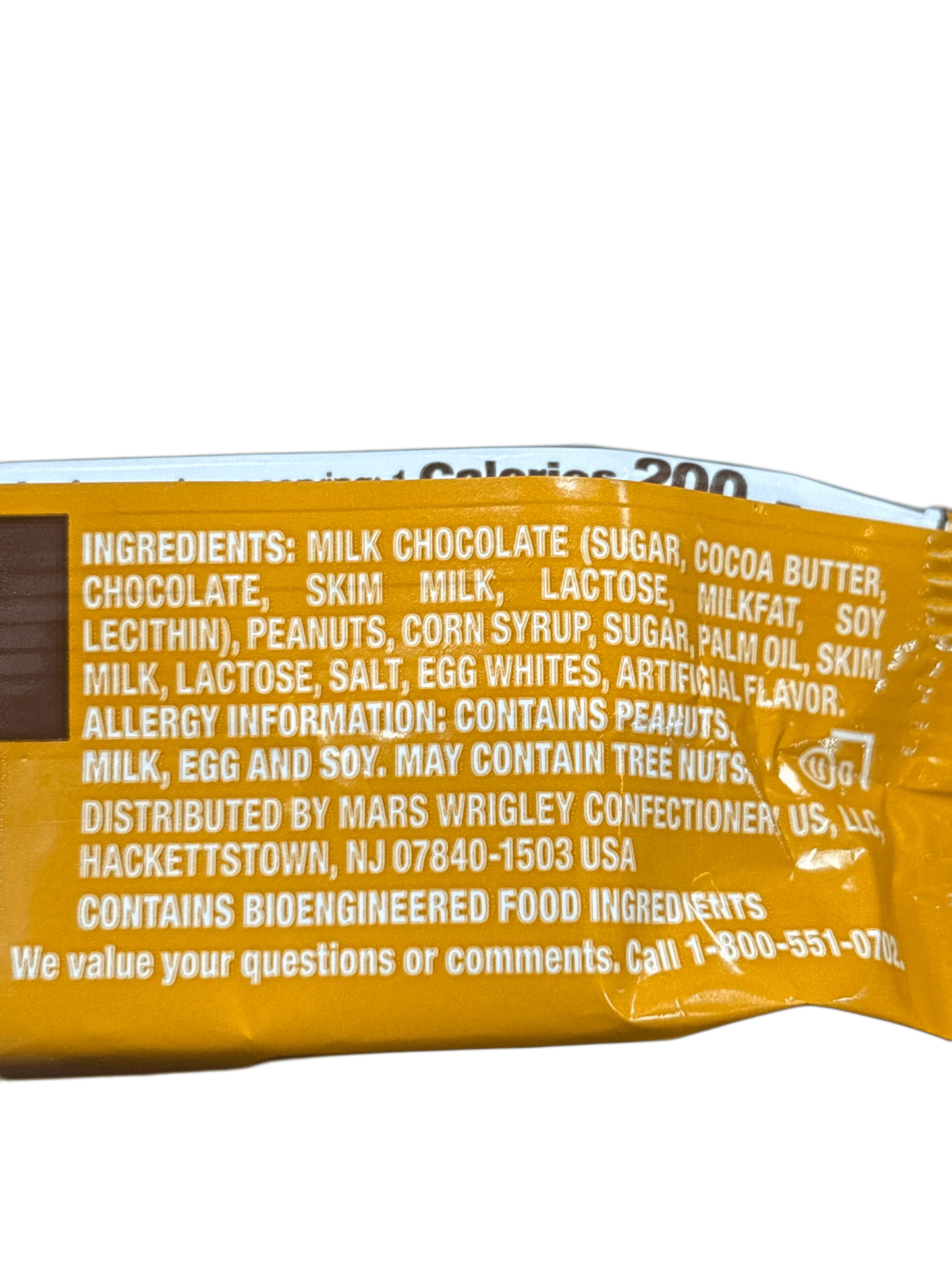 Close-up of chocolate candy bar ingredients list, highlighting peanuts, milk, and soy allergens.