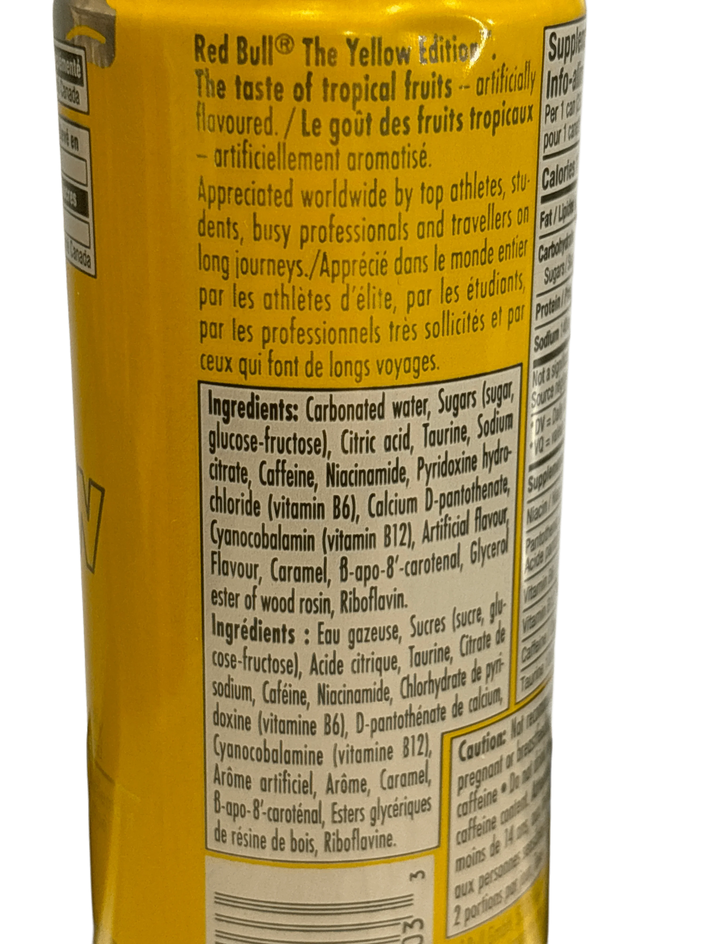Yellow can of Red Bull The Yellow Edition tropical energy drink with ingredients label visible