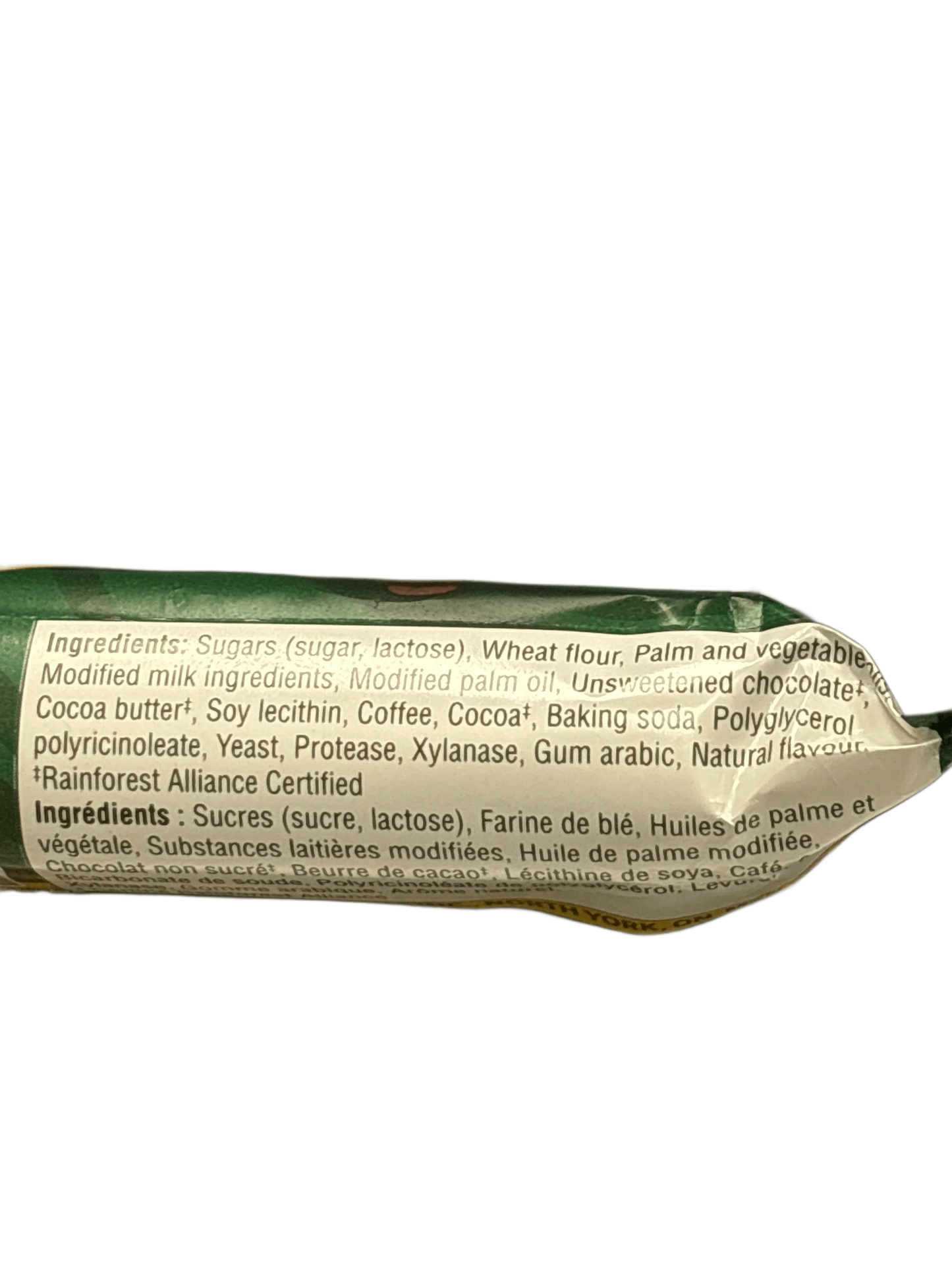 Close-up of exotic snack packaging ingredient list with sugars, wheat flour, palm oil, cocoa, coffee.
