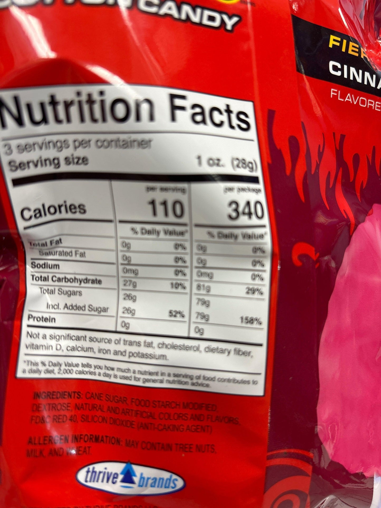 Close-up of fiery cinnamon cotton candy snack packaging with nutrition facts and ingredients.